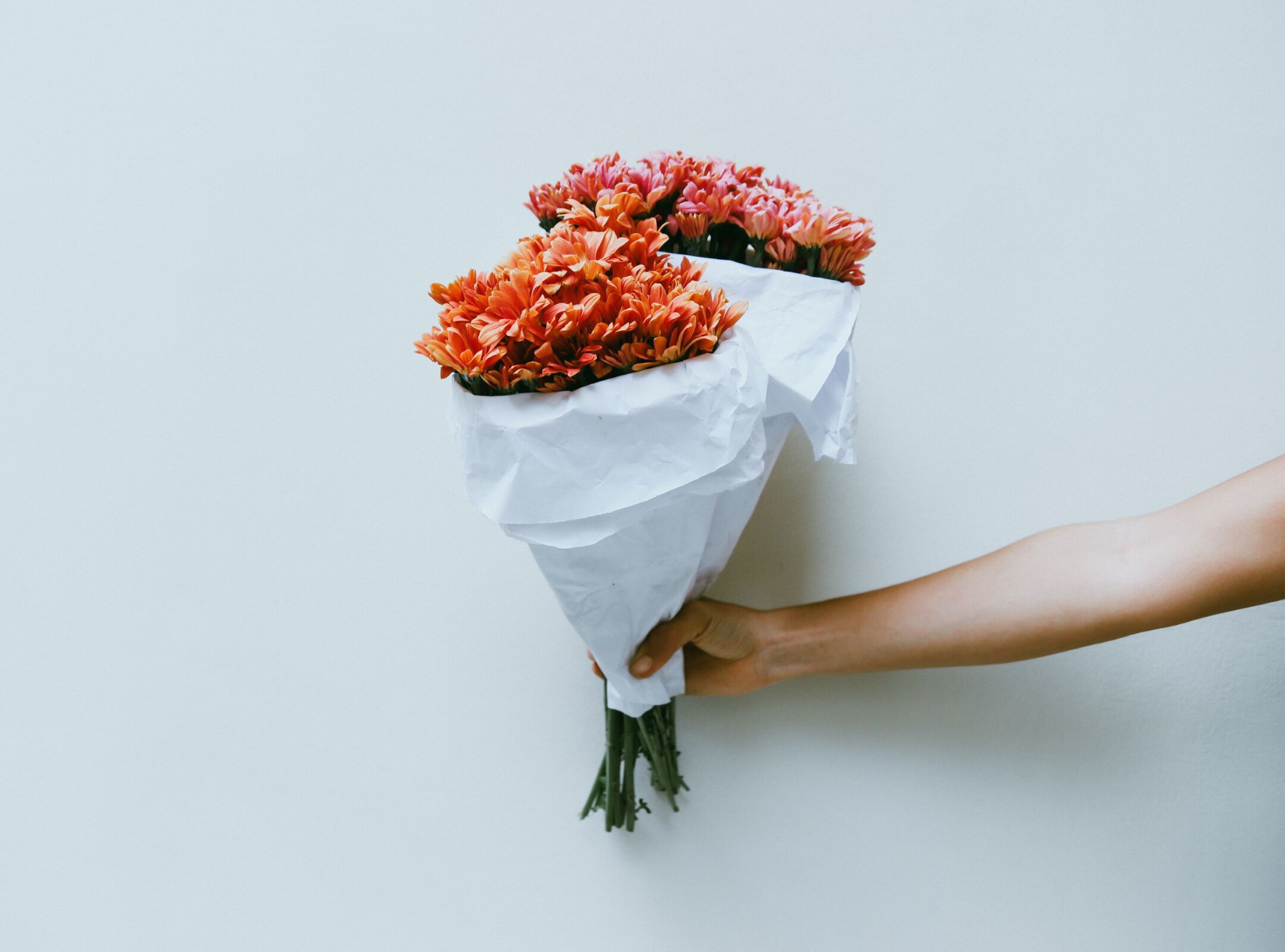hand holding two bouquets
