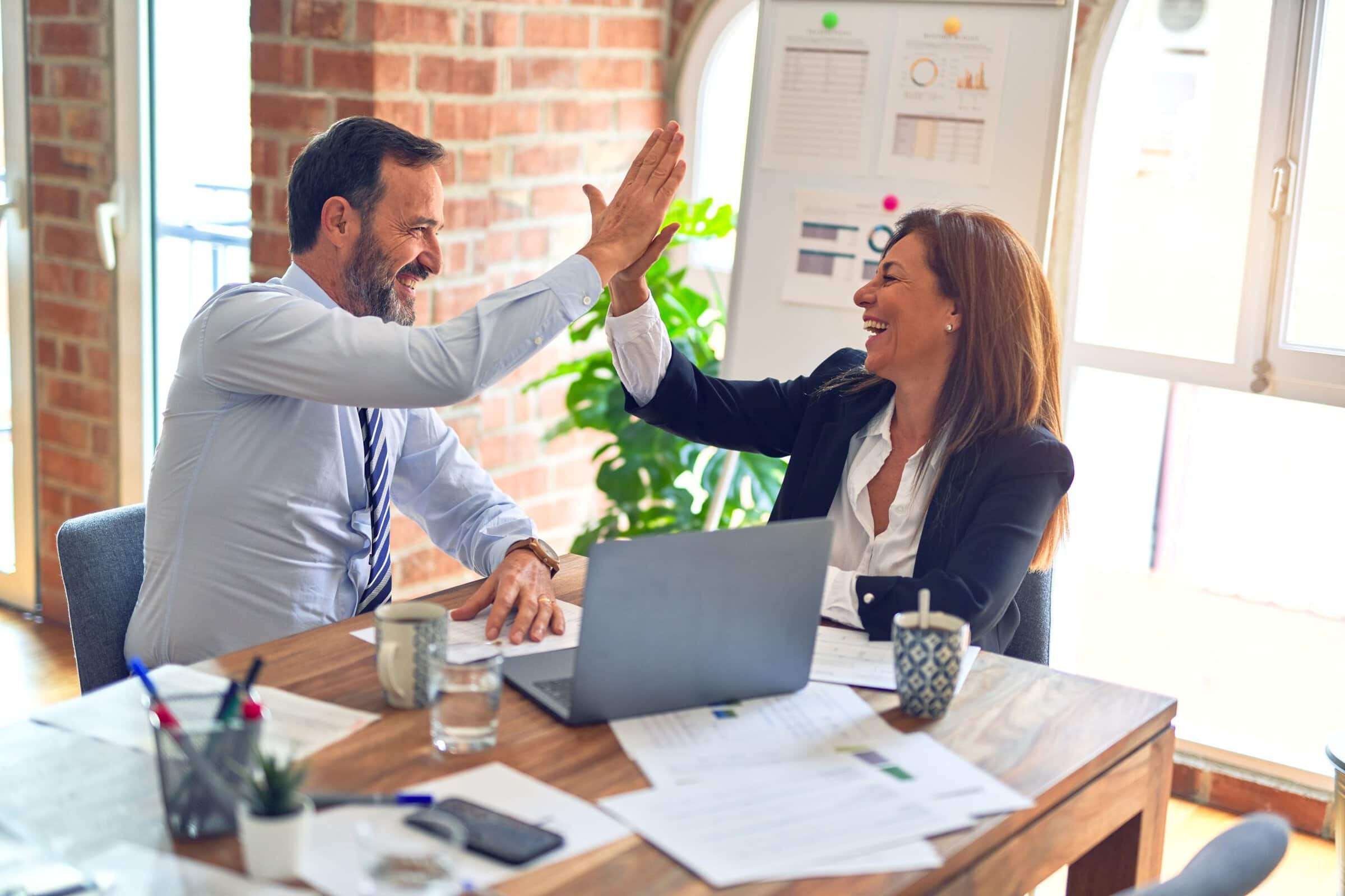 man and woman high five in business meeting